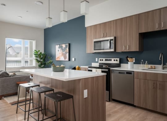 a kitchen with an island and stools in a 555 waverly unit