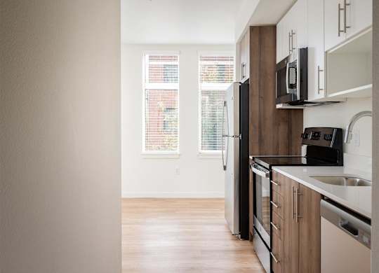 an empty kitchen with a sink and a refrigerator