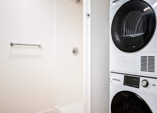 a washer and dryer in a laundry room with a white wall and a