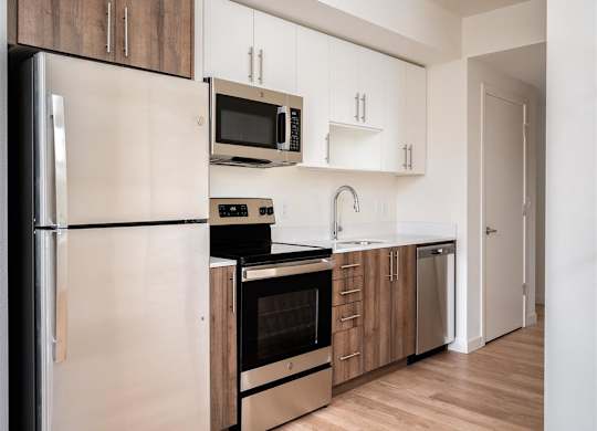 a kitchen with white cabinets and stainless steel appliances and a refrigerator
