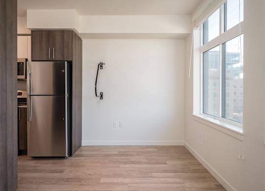 an empty room with a refrigerator and a window