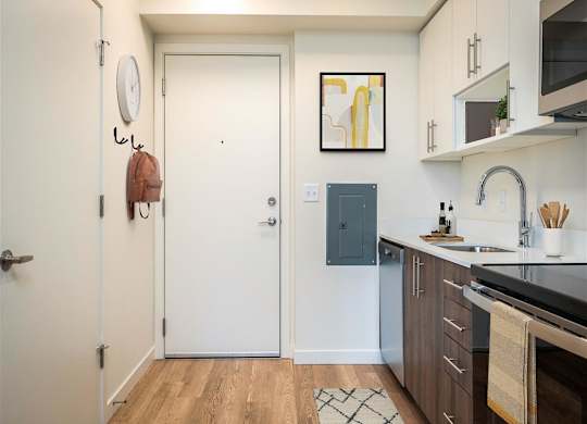 a small kitchen with a sink and a door to the bathroom