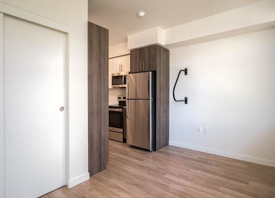 a kitchen with a stainless steel refrigerator in a room with a door