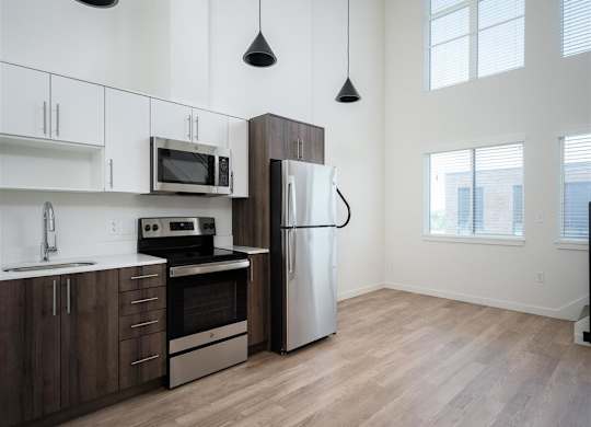 a kitchen with stainless steel appliances and white cabinets and a window