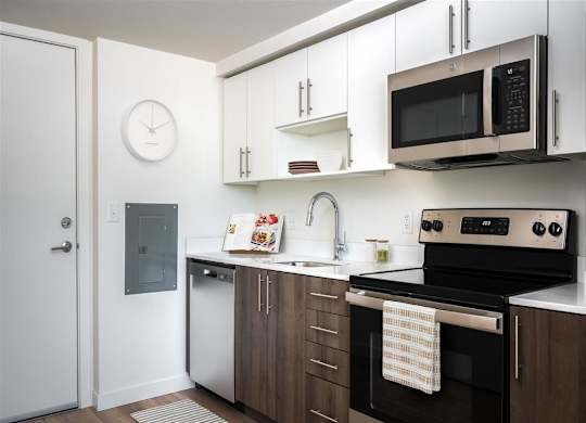 a kitchen with white cabinets and black appliances and a microwave