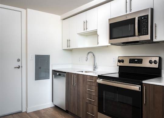 a kitchen with white cabinets and black appliances and a microwave