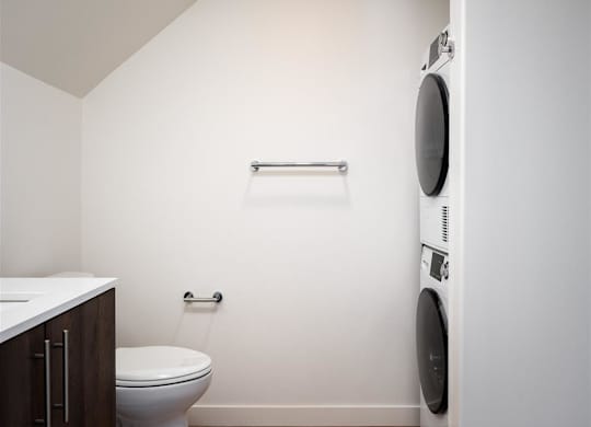 a bathroom with a toilet and a washing machine in it