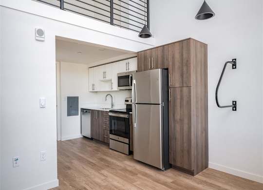 a kitchen with a stainless steel refrigerator and a wooden cabinet