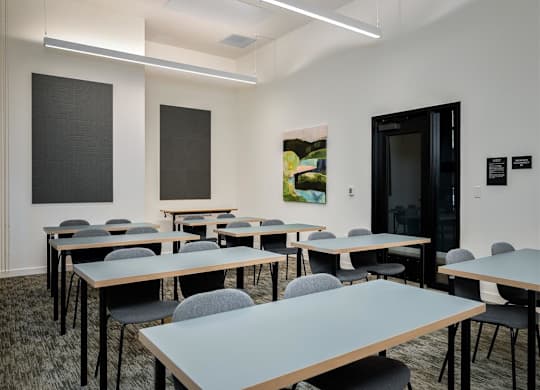 a classroom with tables and chairs and a door