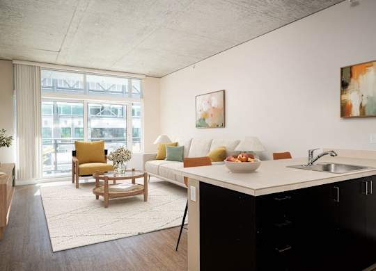 a living room with a kitchen and a large window