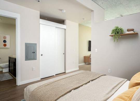 a bedroom with a bed and a bathroom in the background
