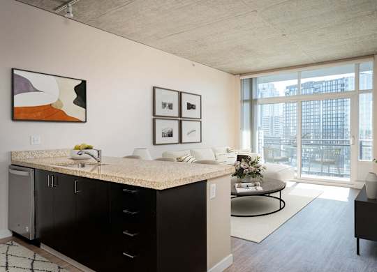 a living room with a large window and a kitchen with a counter top