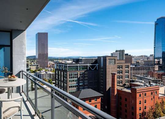 a balcony with a view of the city and a table and chairs