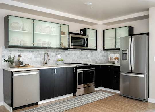 a kitchen with stainless steel appliances and black and white cabinets