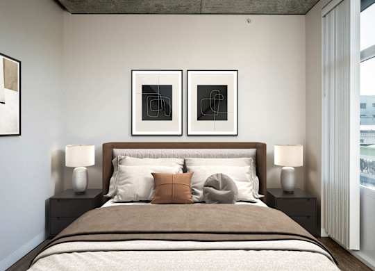 a bedroom with a bed and two pictures on the wall