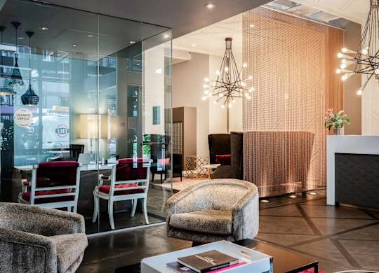 a lobby with chairs and a table and a chandelier