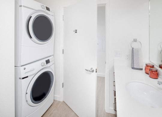 A white washing machine and dryer in a small laundry room.