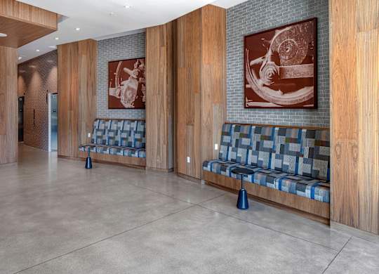 A hallway with two benches and two pictures on the wall.