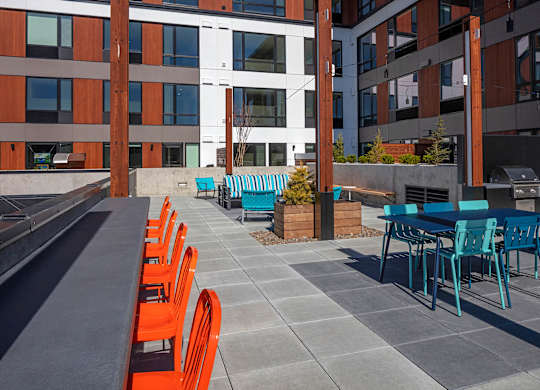 A patio with orange chairs and a table.