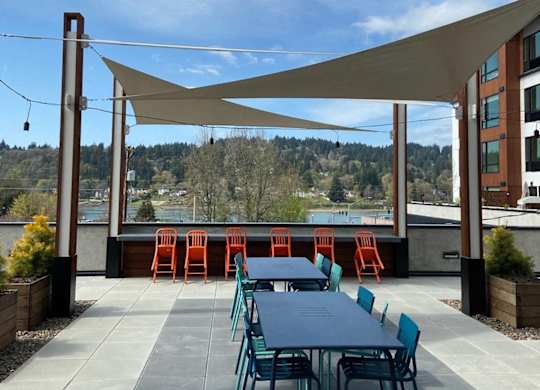 A patio with a table and chairs under a shade sail.