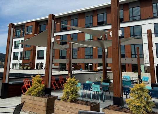 A patio area with chairs and tables is set up outside a building.