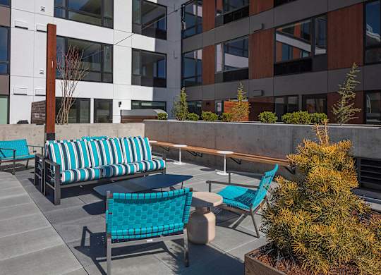 A patio with a blue couch and a table.