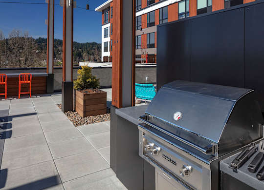 A stainless steel grill is on a patio.