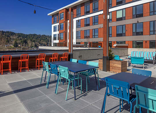 A patio with blue chairs and tables.