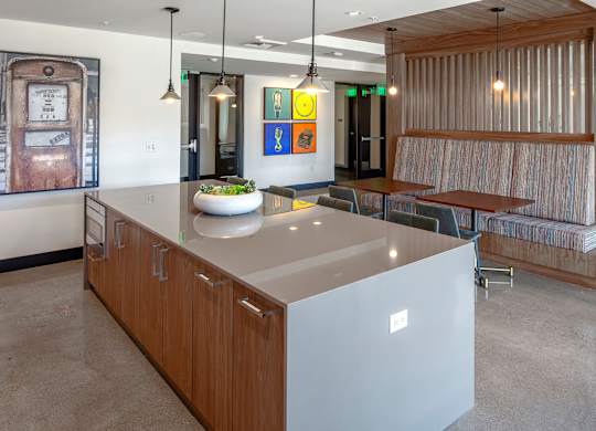 A modern kitchen with a large island and a dining area with a bench.