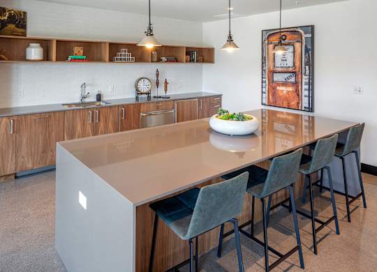 A modern kitchen with a large island and chairs.