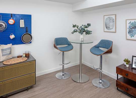 A room with two chairs and a table with a plant on it.