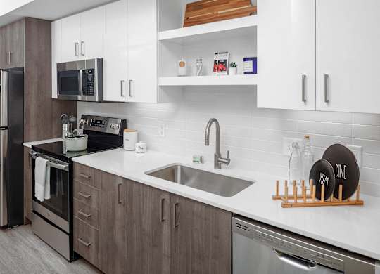 A modern kitchen with a stainless steel refrigerator and a white countertop.