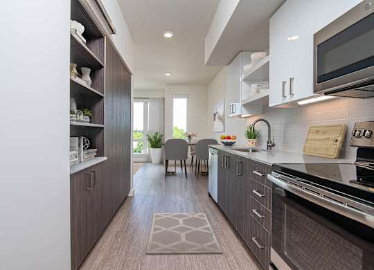 A modern kitchen with dark wood cabinets and a white countertop.