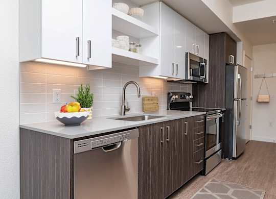 A modern kitchen with stainless steel appliances and wooden cabinets.