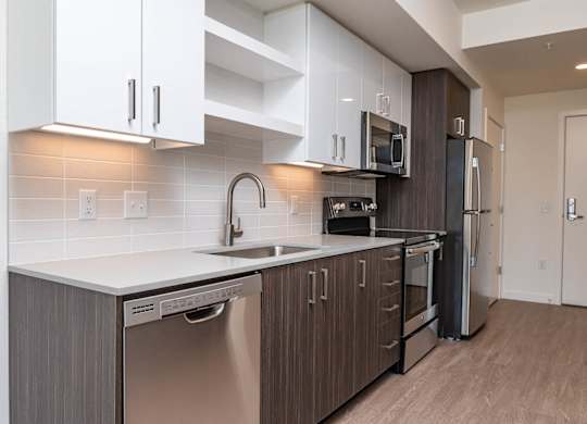 A modern kitchen with a stainless steel dishwasher and oven.