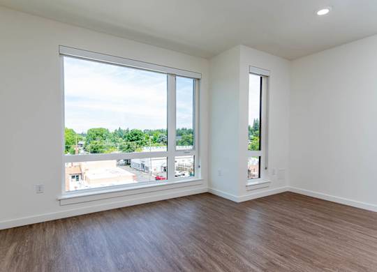A room with a large window and wooden flooring.