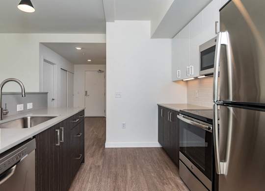 A modern kitchen with stainless steel appliances and wooden cabinets.