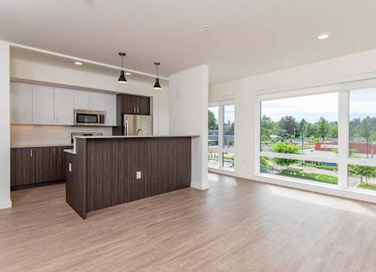 A kitchen with white cabinets and a brown island.
