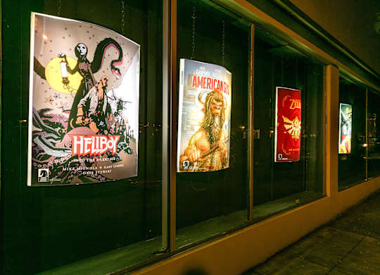 A window display with posters for Hellboy and American Horror Story.