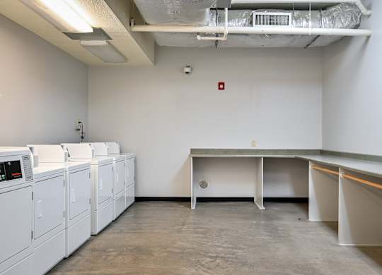 an empty room with washes and dryers in a building