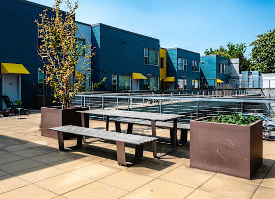 a communal seating area with benches and a tennis court