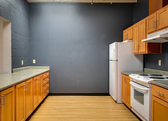 an empty kitchen with wooden cabinets and a white refrigerator