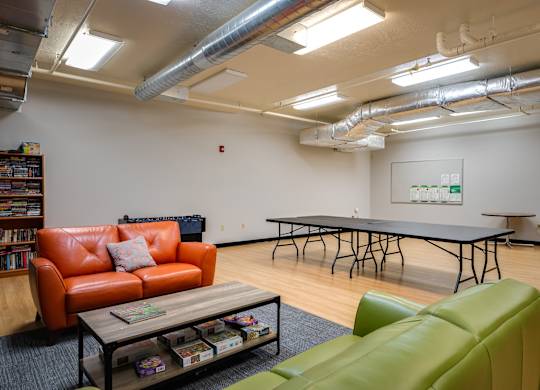 a game room with a ping pong table and couches