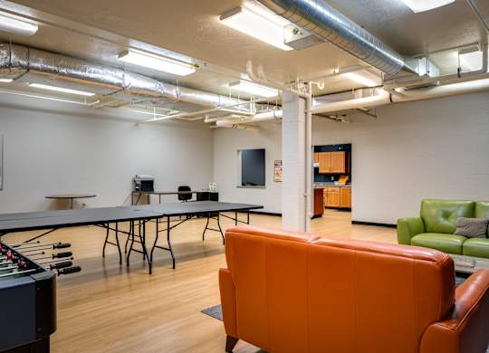 a game room with a ping pong table and couches