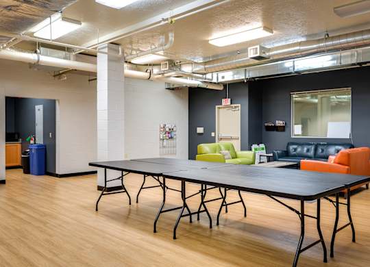 a room with a ping pong table and couches