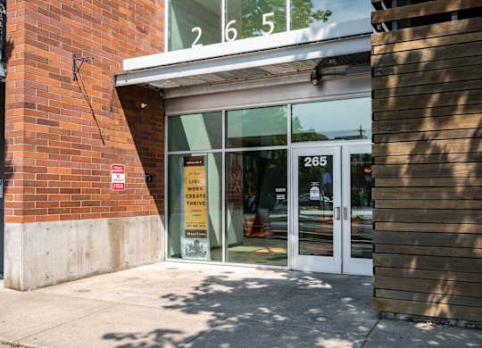 the entrance of a building with glass doors and a sign in the window