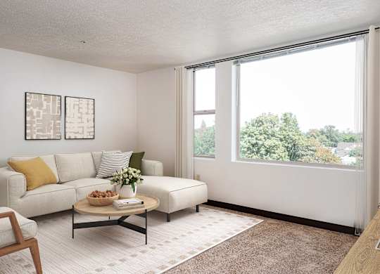 a living room with a large window and a white couch