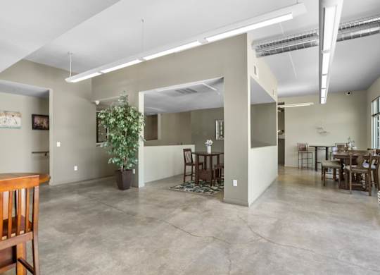 A spacious living room with a dining area and a kitchenette.