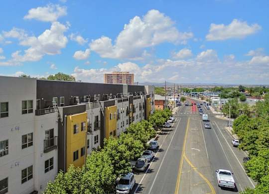 A street view of a residential area with cars parked on the side of the road.