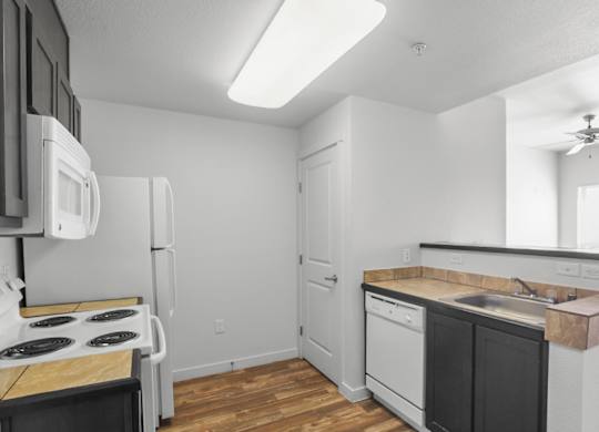A kitchen with a stove, refrigerator, and dishwasher.